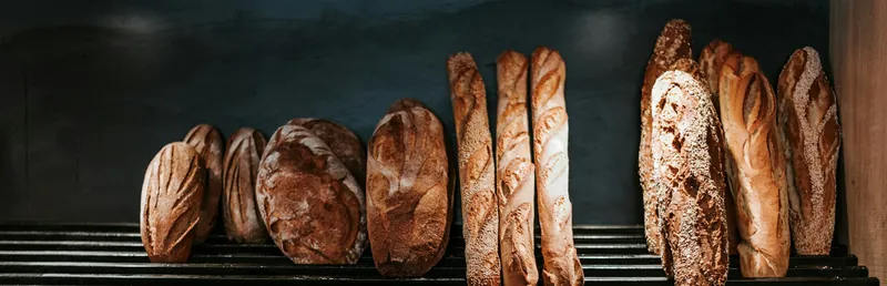 Holzregal voller dunkel gebackener Brote